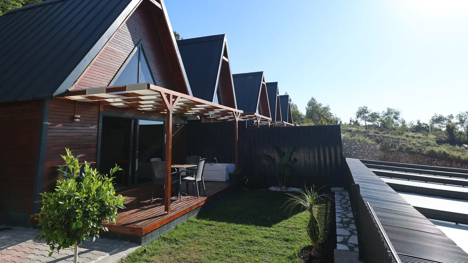 Belen Bungalov — üçgen çatılı ahşap bungalovlar ve dağ manzarası